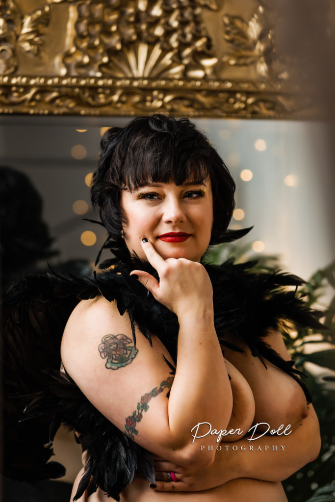 Creative boudoir photo of a woman wearing a feather capelet